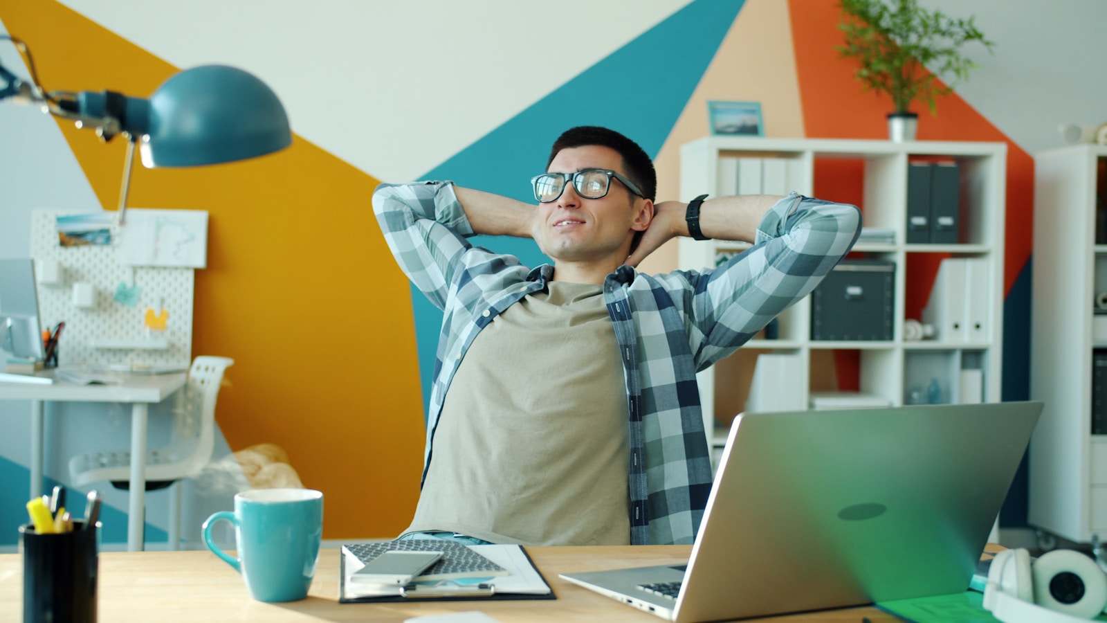 Man relaxing at desk in colorful office